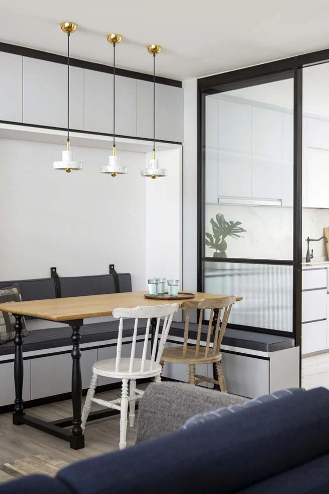 Combinand confortul si multifunctionalitatea, un colt german proiectat intr-un apartament cu dulapuri incorporate aproape de tavan si sertare sub scaune.