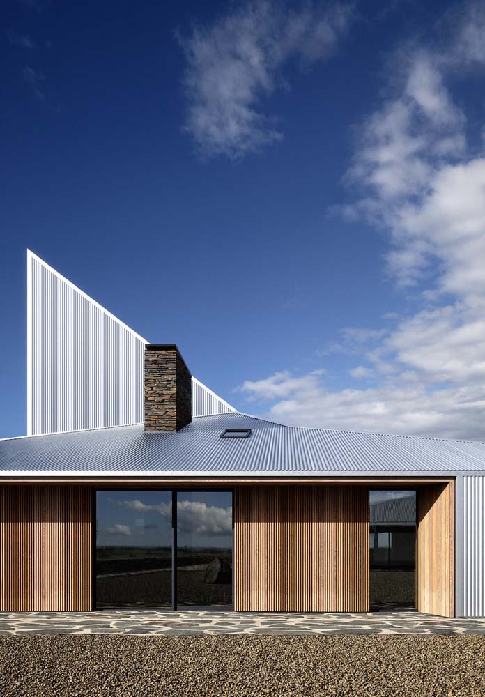 Aceasta fatada a unei case cu un acoperis expus arata uimitor cu placile metalice.