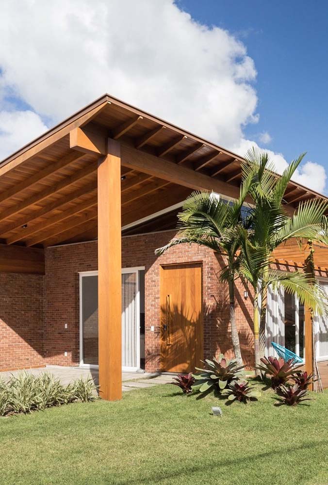 Este posibil sa impaci fatada unei case cu un acoperis modern pe jumatate de apa cu materiale rustice, precum ceramica si lemnul.