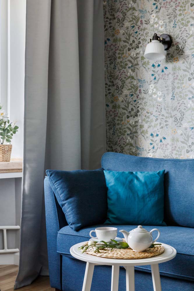 Flores azuis para combinar com o sofá. Considere o que você já tem na decoração antes de escolher o papel de parede