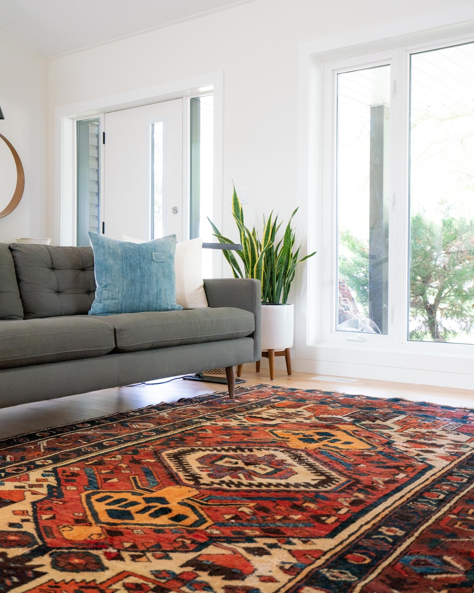 Teal 2-seat couch and red area rug. Cum sa alegi covoarele de lana potrivite pentru casa ta: sfaturi si idei