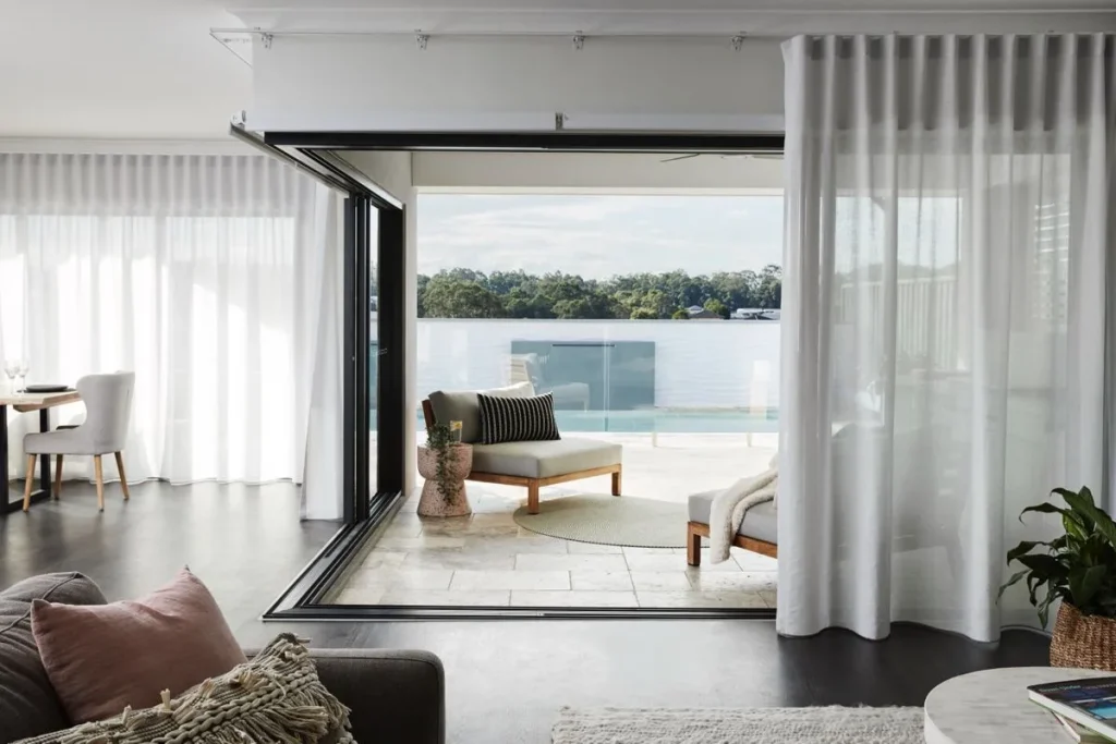 Cum Să Alegi Perdelele Potrivite pentru Fiecare Cameră: Ghidul pentru Living, Dormitor și Bucătărie Living modern cu deschidere spre terasă, decorat cu draperii albe vaporoase, mobilier minimalist.
